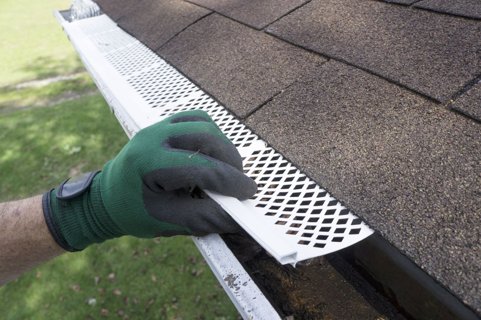 hand-with-glove-installing-gutter-guards