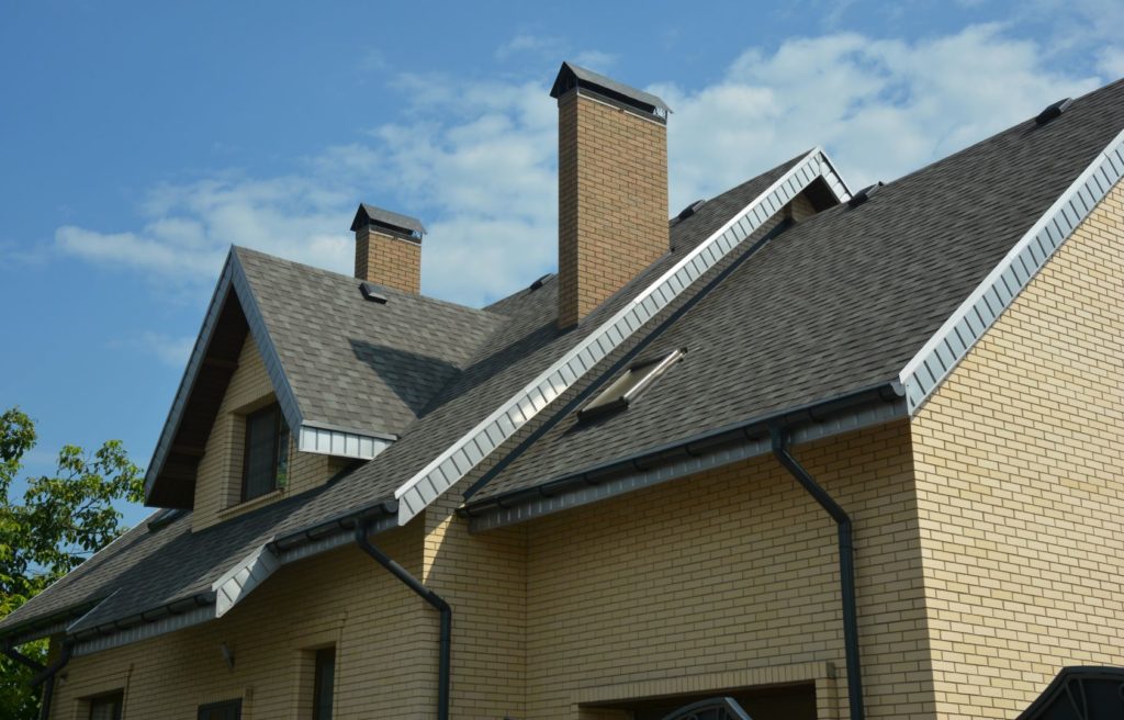 A close-up of a double complex roof of a brick house construction